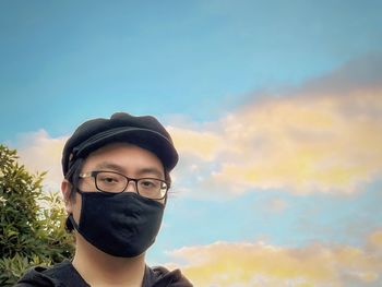 Portrait of handsome young man against sky during sunset