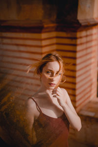 Portrait of woman standing against wall