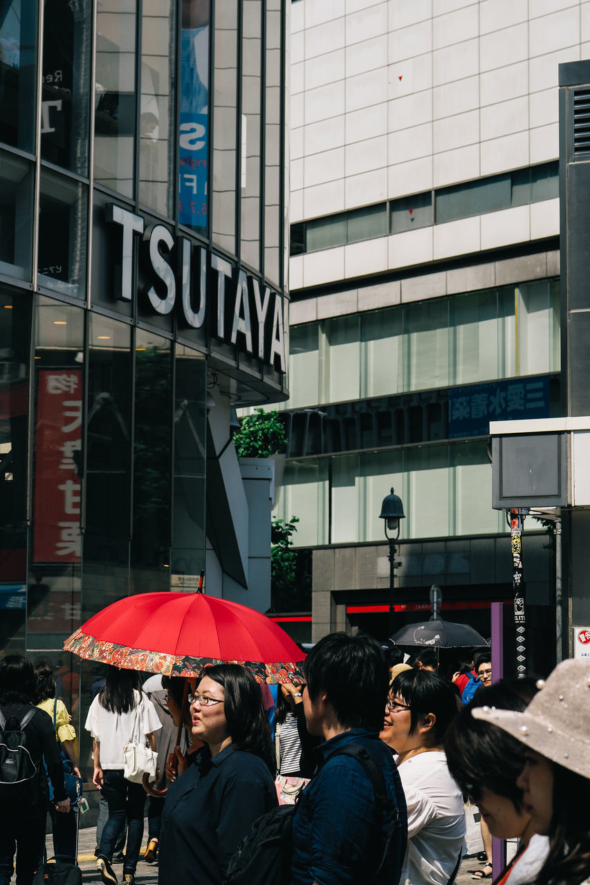 building exterior, architecture, real people, built structure, city, large group of people, men, text, women, communication, outdoors, day, crowd, people