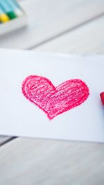 Close-up of heart shape on pink table