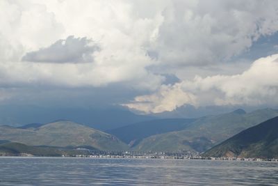 Scenic view of sea and mountains against sky