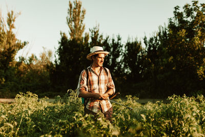 Man wearing hat on field against trees