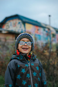 Portrait of cute boy wearing knit hat standing outdoors during winter