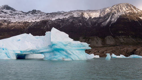 Scenic view of frozen river and mountain against sky