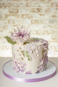 Artistic wedding cake with edible dahlia flower. front view.