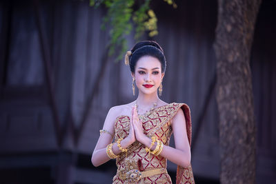 Young woman in traditional clothing looking away while standing outdoors