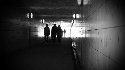 People walking in illuminated tunnel