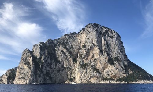 Rock formations by sea against sky