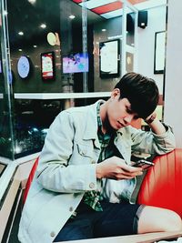 Young man using smart phone at waiting area