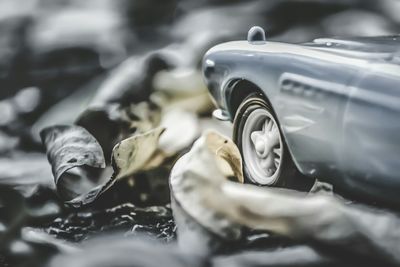 Cropped image of toy car by fallen dry leaves