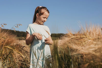 Woman standing on field against sky