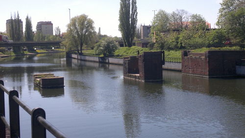 Scenic view of river against sky in city