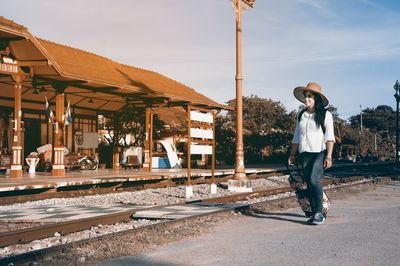 Woman walking with luggage at railroad station