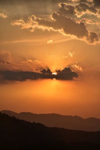 Scenic view of silhouette mountains against romantic sky at sunset