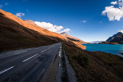 Road amidst mountains against blue sky