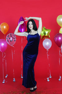 Portrait of a young woman with red balloons
