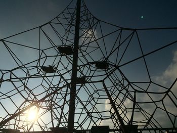 Low angle view of silhouette cables against sky during sunset