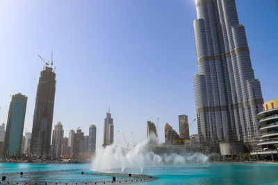 The dancing fountains downtown and in a man-made lake in dubai, uae in front of the burj khalifa 
