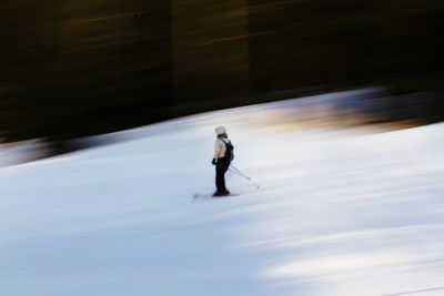 Blurred motion of person skiing on snowcapped mountain