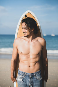 Mid adult man standing at beach against sky