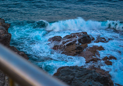High angle view of waves breaking on rocks
