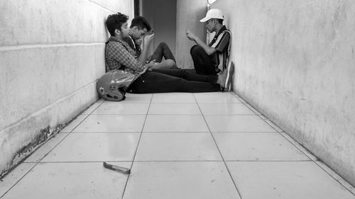 Side view of men sitting on tiled floor