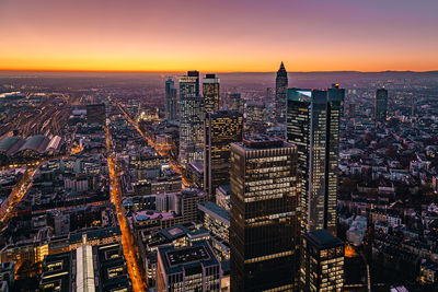 Aerial view of illuminated buildings in city at dusk