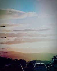 Cars on road against sky during sunset