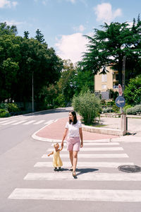 Rear view of woman with dog against plants