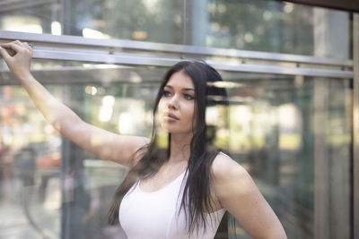 Fashionable young woman standing by window
