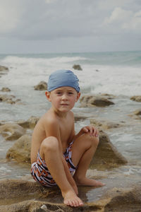 Full length of boy sitting on beach