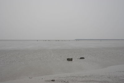 View of calm beach against clear sky