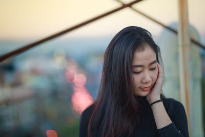 Close-up of young woman against blurred background