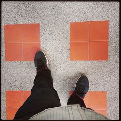 Low section of woman standing on tiled floor