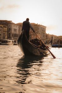 Man in boat sailing on sea against sky