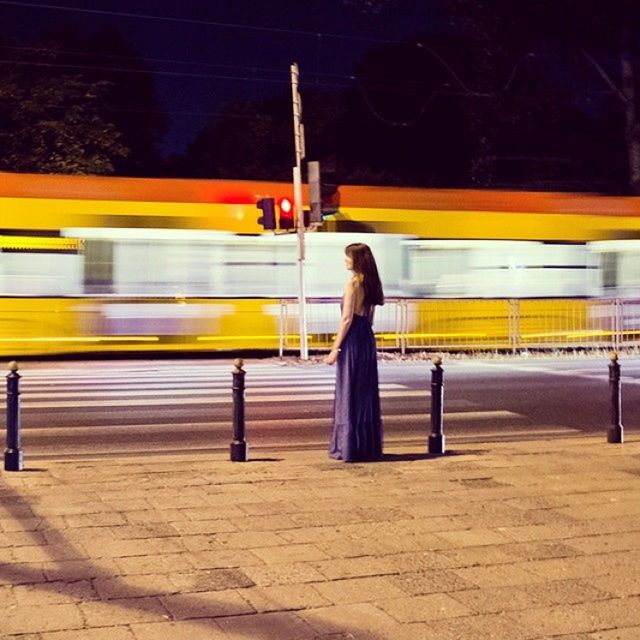 transportation, railroad station platform, public transportation, railroad track, illuminated, railroad station, night, rail transportation, yellow, train - vehicle, mode of transport, lifestyles, travel, men, speed, full length, on the move, blurred motion