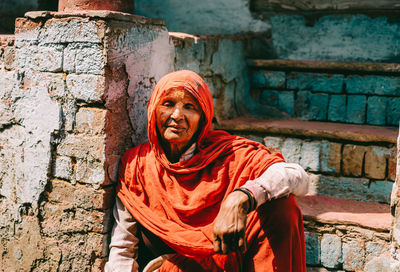 Portrait of man sitting against wall