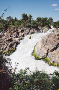 Scenic view of waterfall against sky