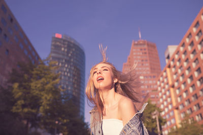 Young woman standing against building in city