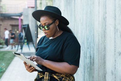 Side view of young woman using mobile phone