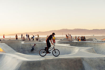 People riding bicycles against sky