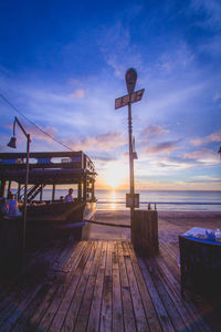 Pier over sea against sky during sunset