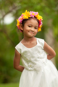 Portrait of a smiling girl standing against pink flower