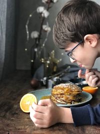 Side view of boy preparing pancake at home