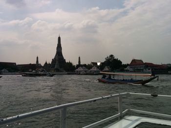 Boat in sea against cloudy sky