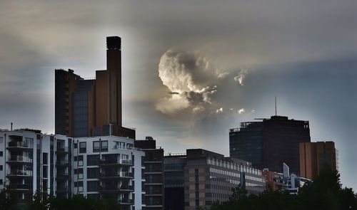 Smoke emitting from factory against sky