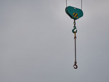 Low angle view of chain hanging against white background