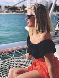 Beautiful woman sitting on boat in sea