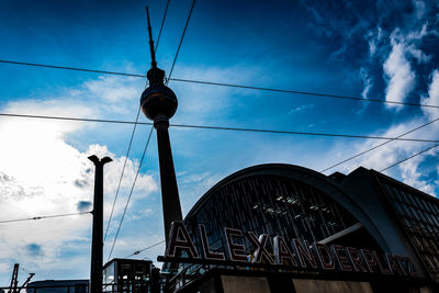 Low angle view of communications tower and buildings against sky