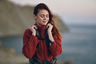 Young woman looking away while standing in sea